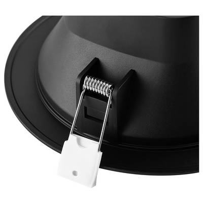 Close-up of a black recessed light fixture with a spring clip and white connector attached, shown against a white background.