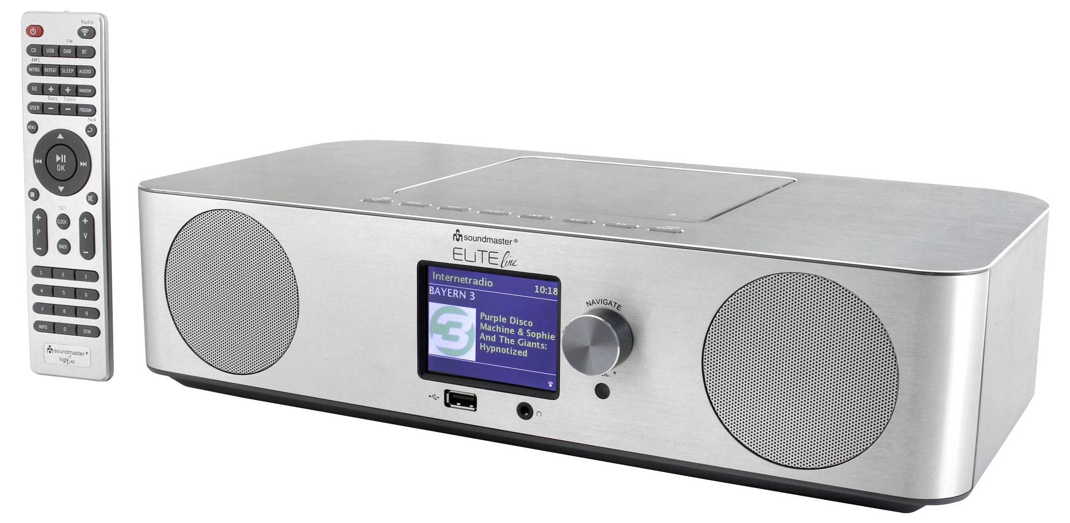 Silver tabletop stereo radio with two speakers, a central display, tuning knob, USB port, and remote control shown beside it.