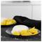 Two black plates of coconut rice with sliced mango, one plate in the foreground on a countertop.