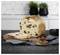 Loaf of raisin bread on a cutting board, with one slice cut and laid in front on a kitchen countertop.