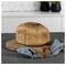Loaf of crusty bread on a wooden board with a blue cloth in a kitchen setting.