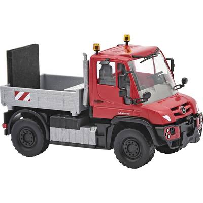 Red toy dump truck with a red cab, gray cargo bed, black wheels, and warning lights on top, shown on a white background.