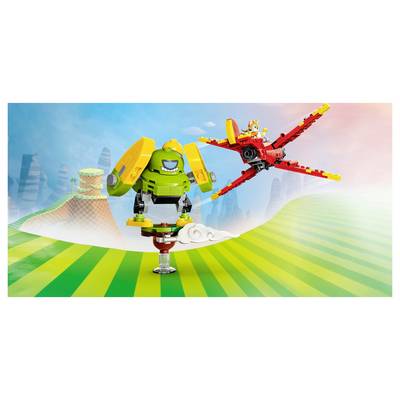 LEGO-style green robot balancing on one foot while a red bird flies beside it over a striped green landscape with clouds and mountains.