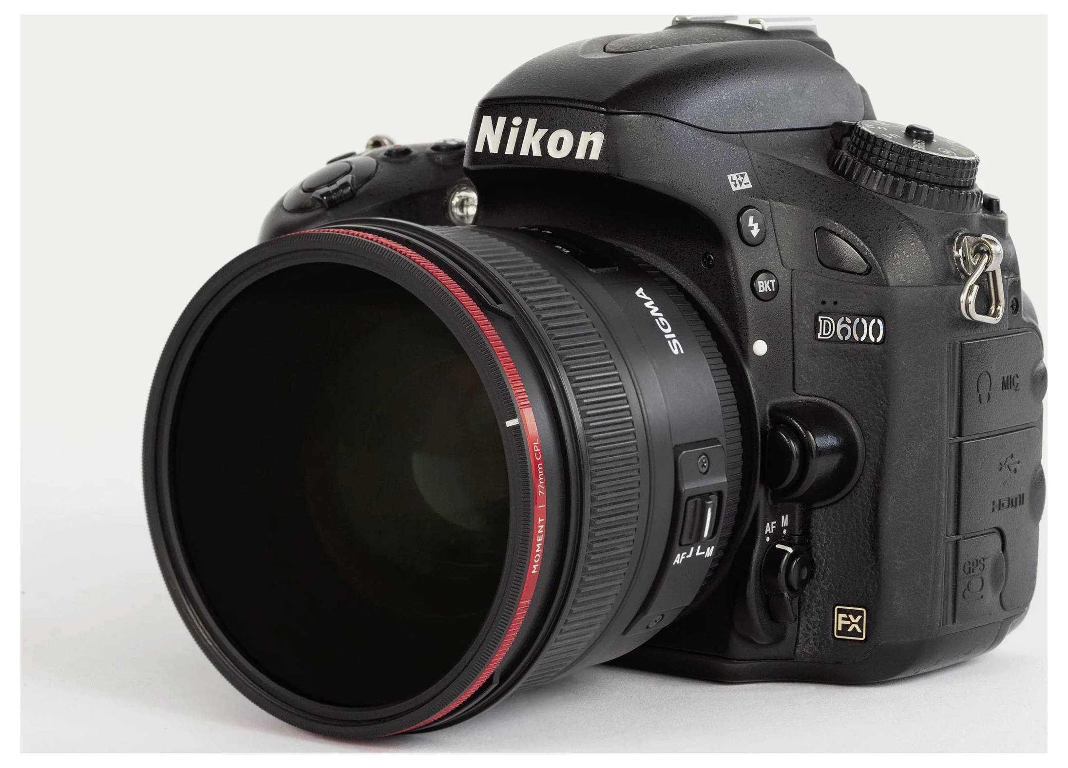 Black Nikon D600 DSLR camera with attached Sigma lens, shown in three-quarter view on a plain light background.
