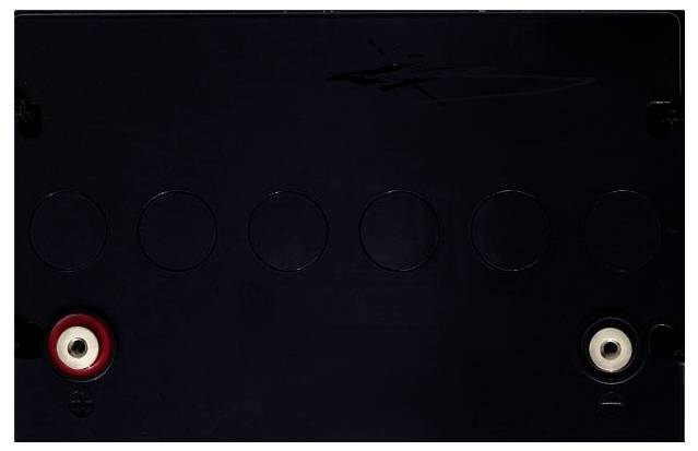 Black rectangular electrical panel with six circular knockout marks and red and white terminal ports at the bottom corners.