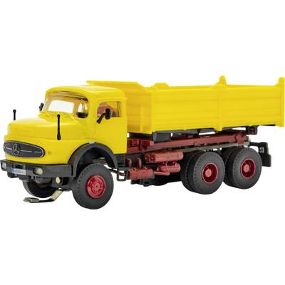 Yellow dump truck toy model shown in side view, with red wheels and undercarriage on a white background.