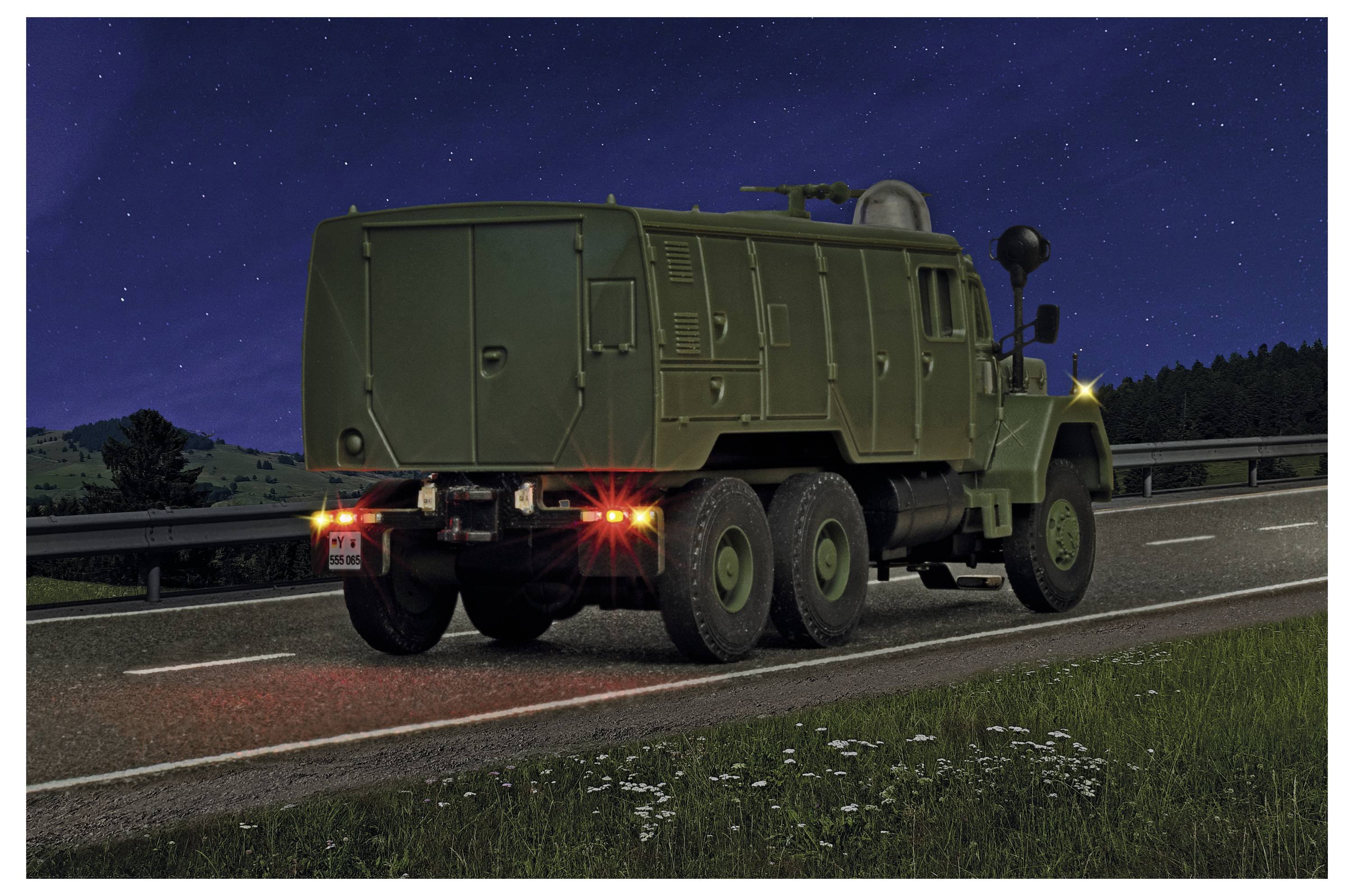 Military-style 6-wheeled green truck driving on a highway at night under a starry sky, rear view with brake lights on.