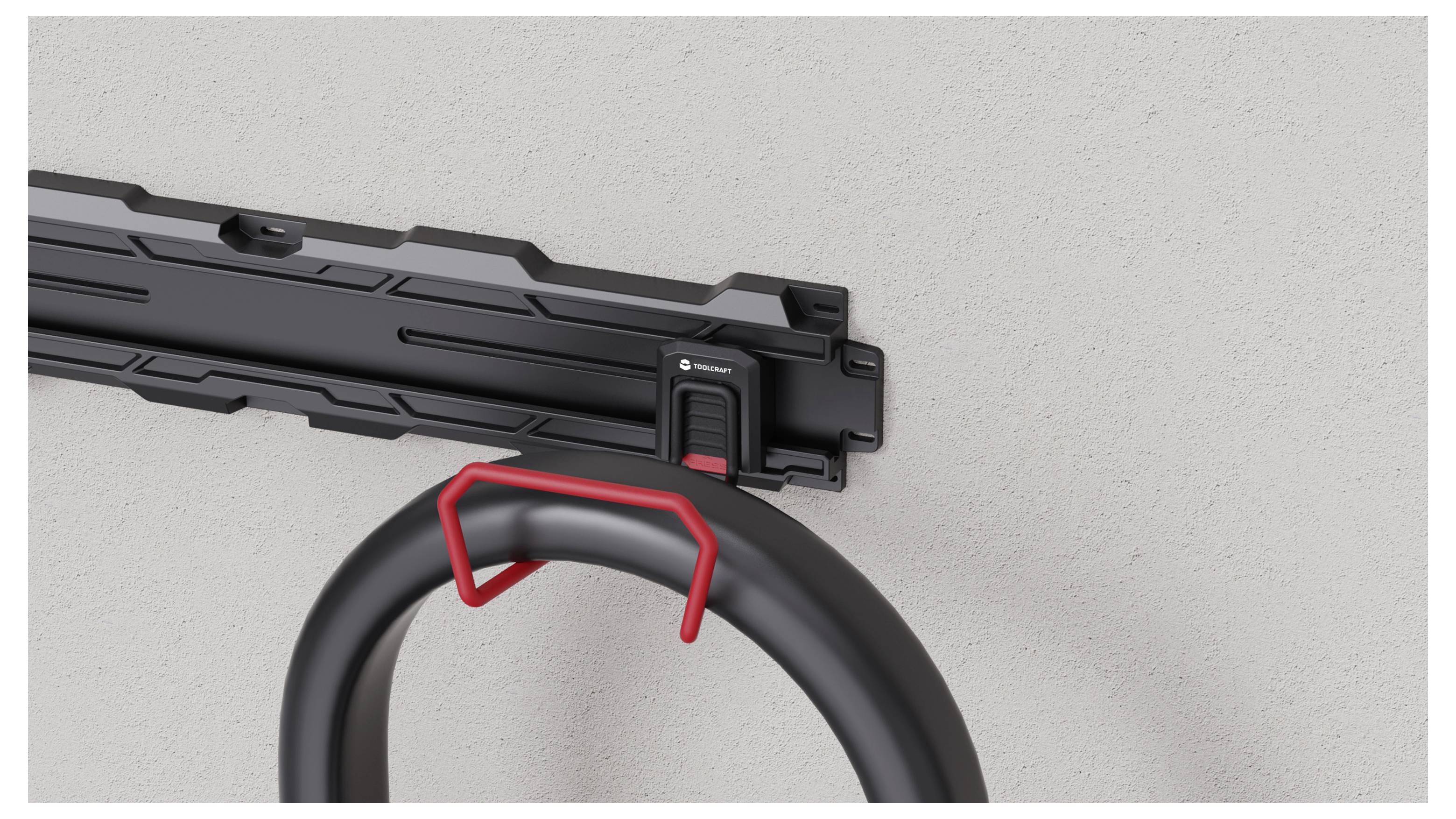 Close-up of a black folding lock and its wall-mounted bracket, with the lock loop guiding into the holder for storage.<br>
