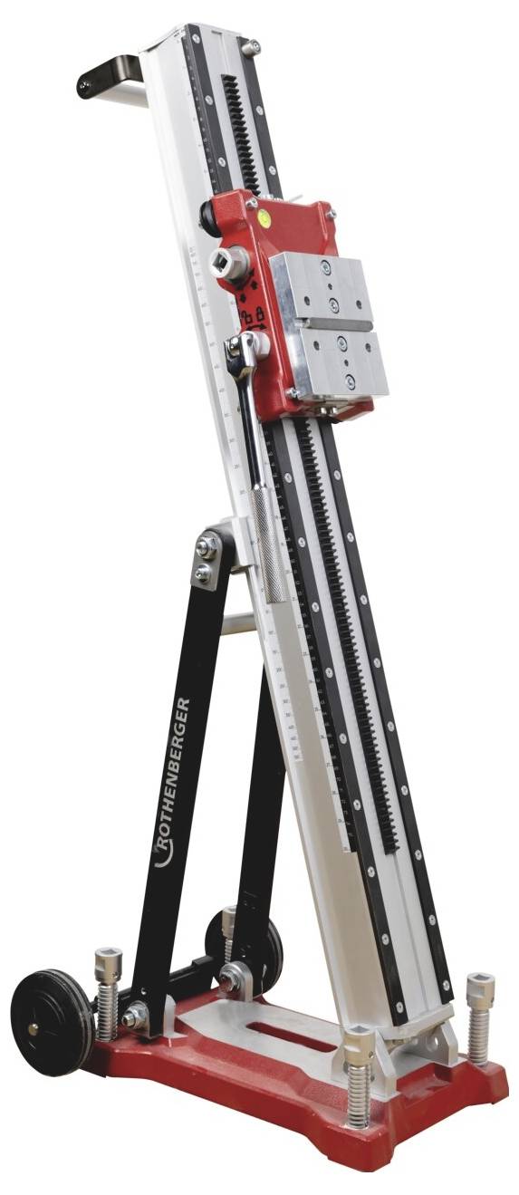 Adjustable red-and-silver mechanical lifting stand with a tall vertical rail, crank handle, and support legs on a base<br>