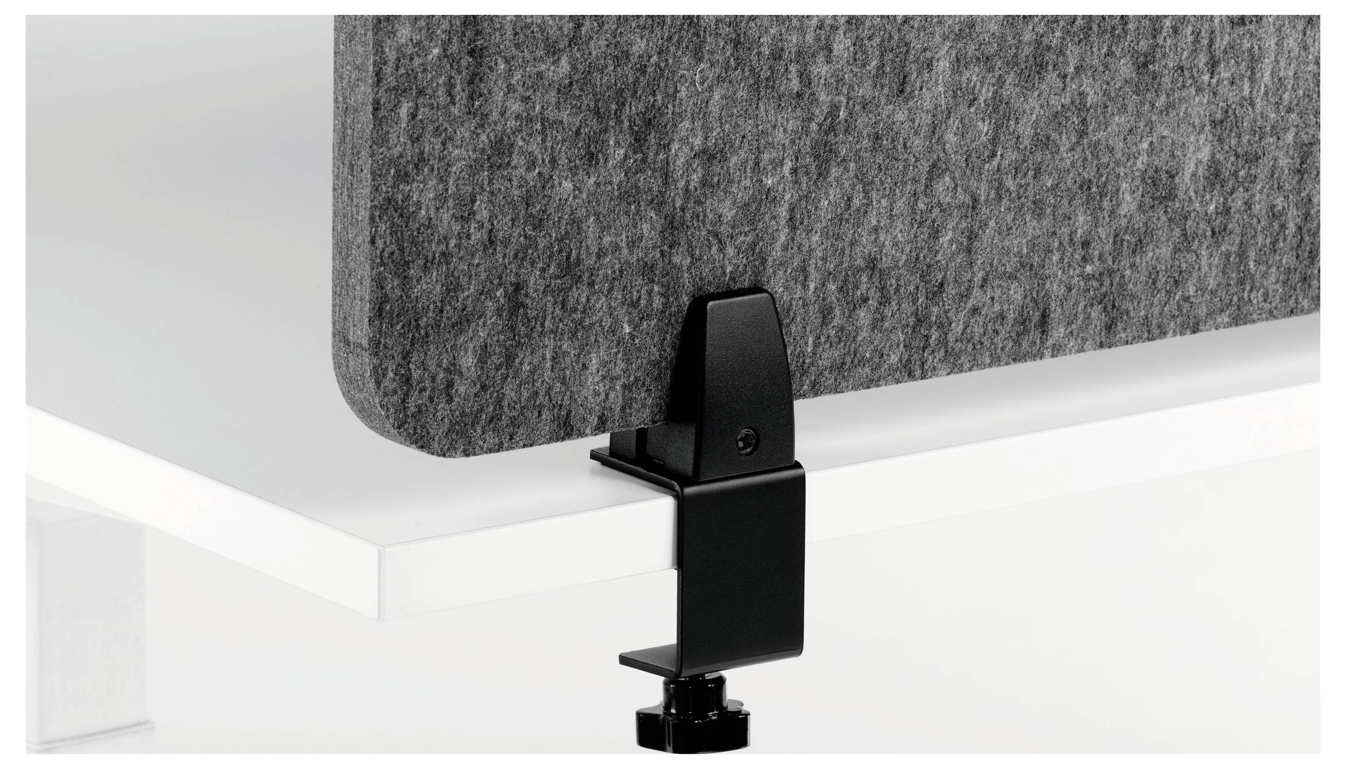 Close-up of a black metal clamp attaching a gray fabric panel to a white desk or partition edge.