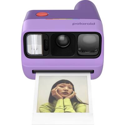 Purple Polaroid instant camera printing a photo of a woman resting her face on her hands<br>