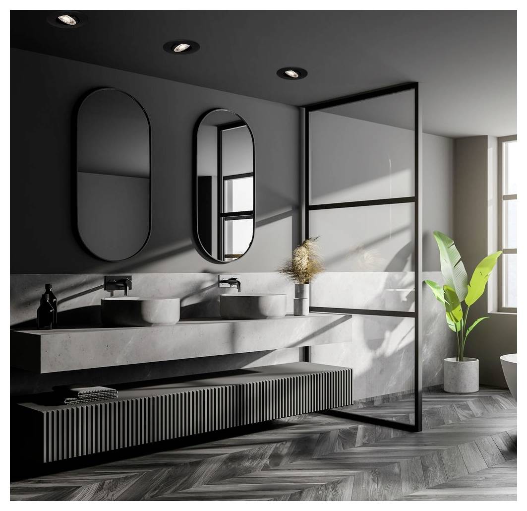 Modern gray bathroom with double sinks, round mirrors, glass shower divider, and a potted plant by a sunlit window.