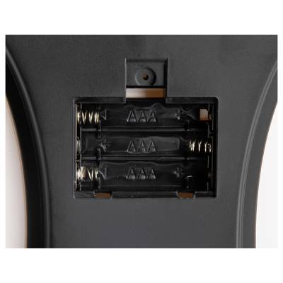 Open battery compartment on a device, showing slots for three AAA batteries with visible spring contacts and polarity markings.