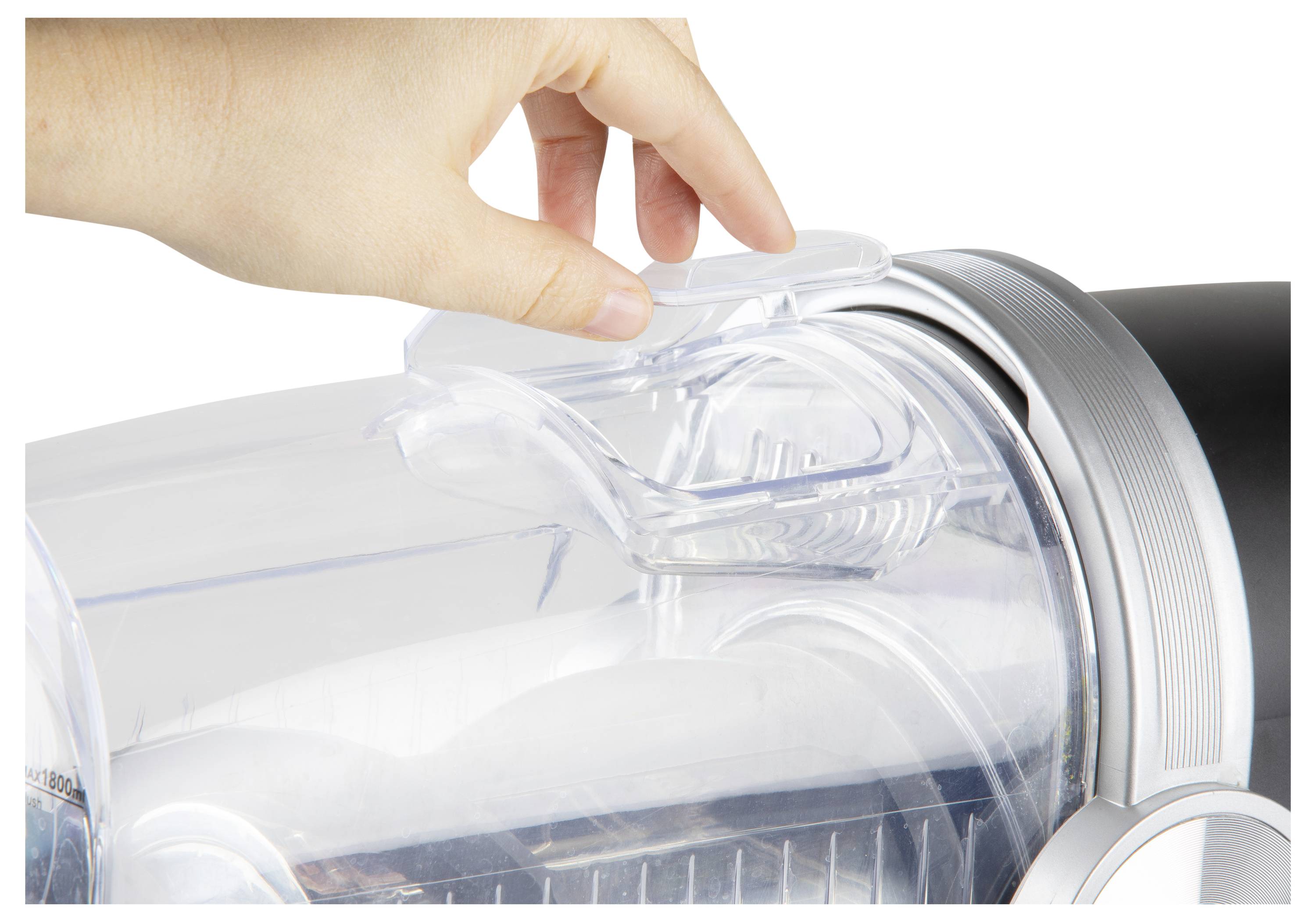 Hand opening the lid of a clear vacuum canister, exposing the dust bin and filter inside.<br>