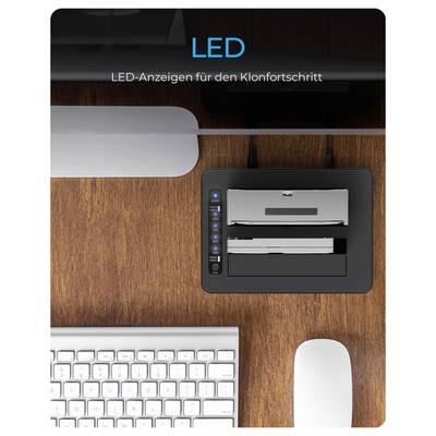 Desk setup with a keyboard, mouse, and docking station next to a monitor stand; text reads 'LED' and 'LED-Anzeigen für den Klonfortschritt' over a wooden surface.
