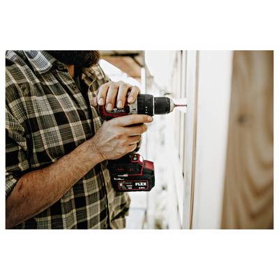 Close-up of a person using a cordless drill to drive a screw into a wall or frame during construction or repair.