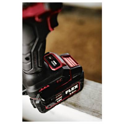 Close-up of a FLEX cordless power tool battery pack with red release button and charging contacts on a work surface.