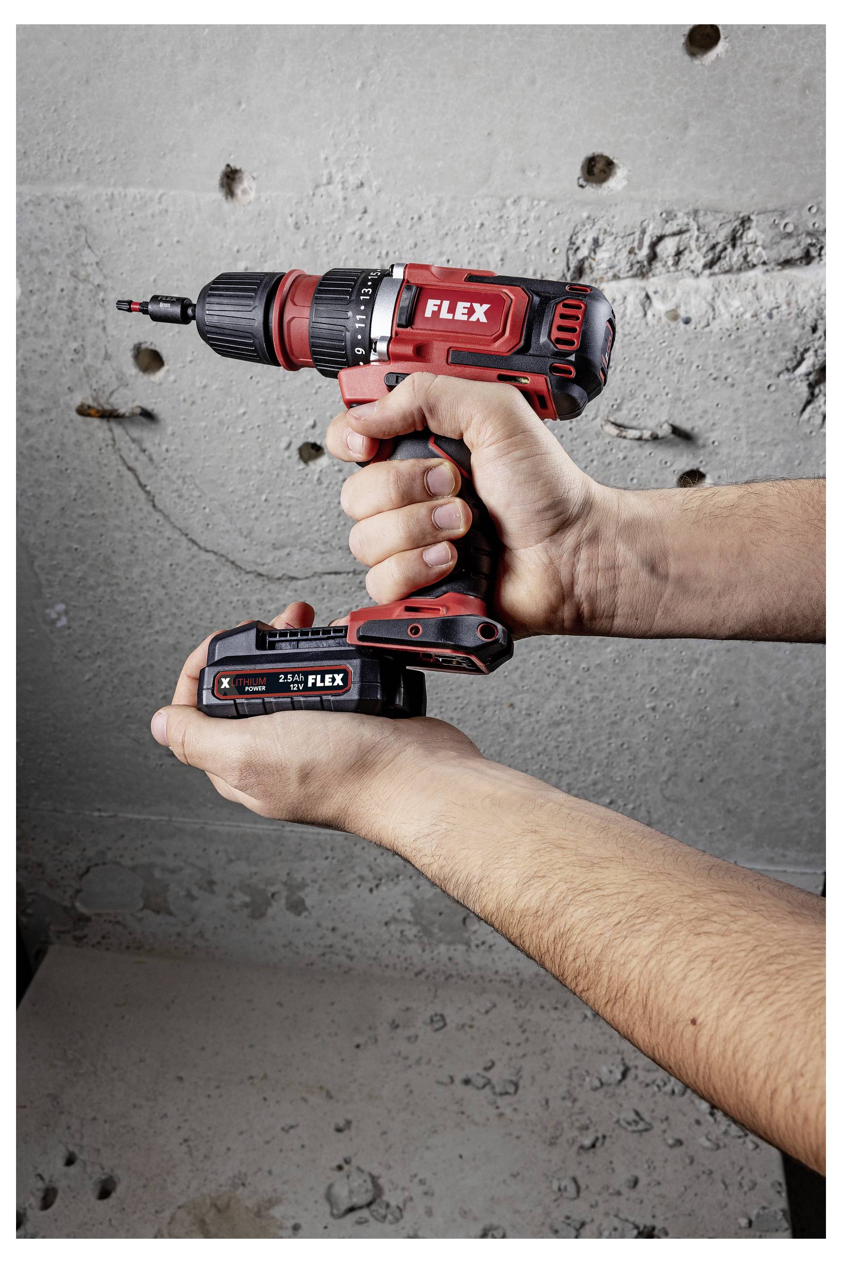 Hands holding a red FLEX cordless drill/driver with battery pack against a concrete wall.