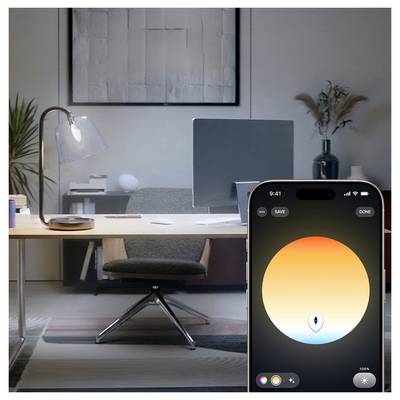 Smartphone screen showing a color picker with a large warm orange-to-blue gradient circle, 'SAVE' and 'DONE' buttons, displayed in a modern office workspace.