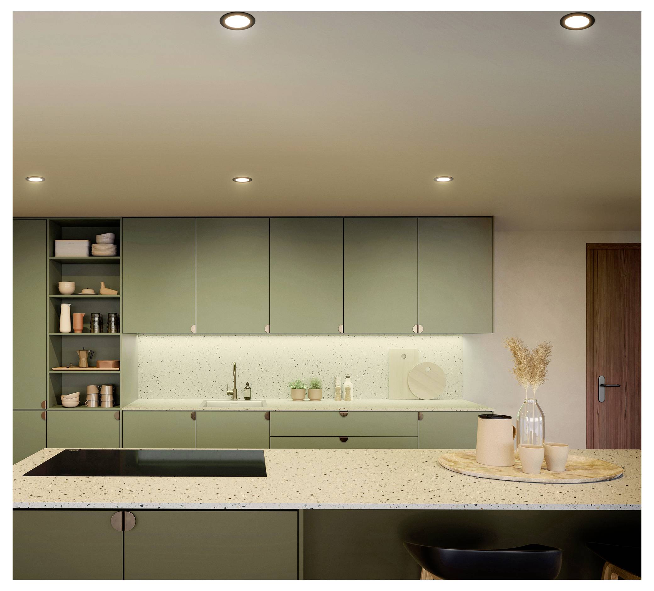 Modern kitchen with sage-green cabinets, white speckled island, integrated sink and cooktop, open shelves, and a tray with vase and cups on the counter.