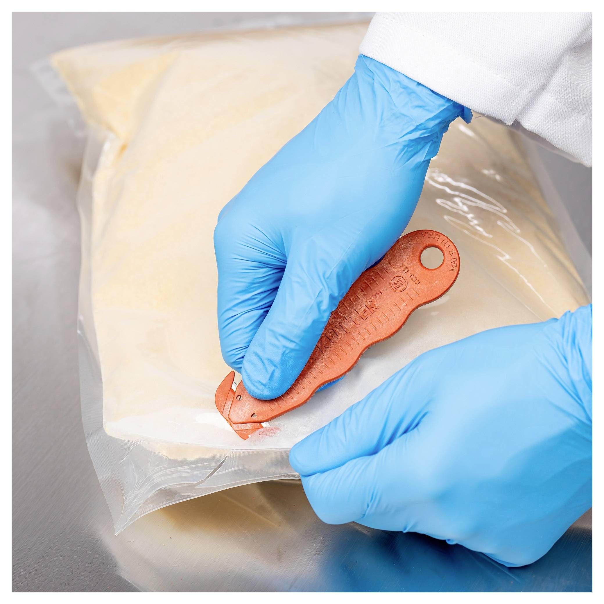 Gloved hands use an orange sealing tool to close a clear plastic bag of food or dry goods.