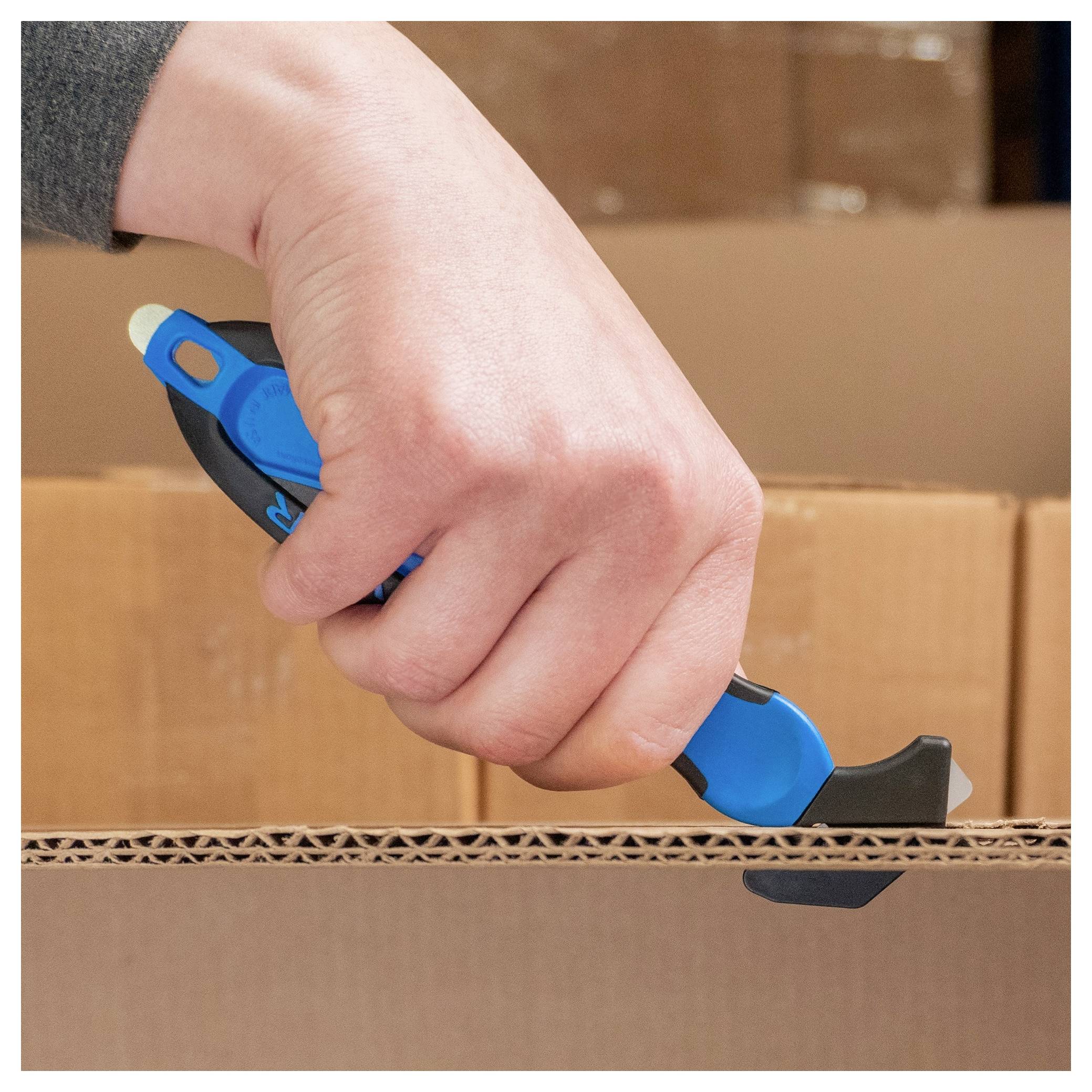 Hand using a blue utility knife to cut open a cardboard shipping box.