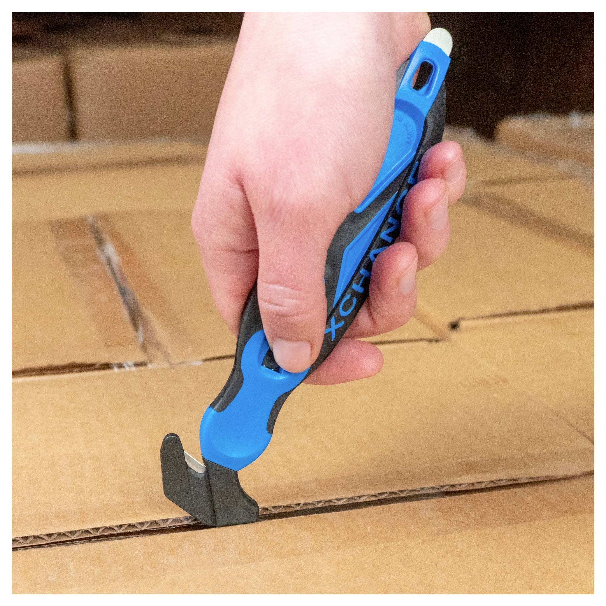 Hand using a blue box cutter to slice open a cardboard shipping box.<br>