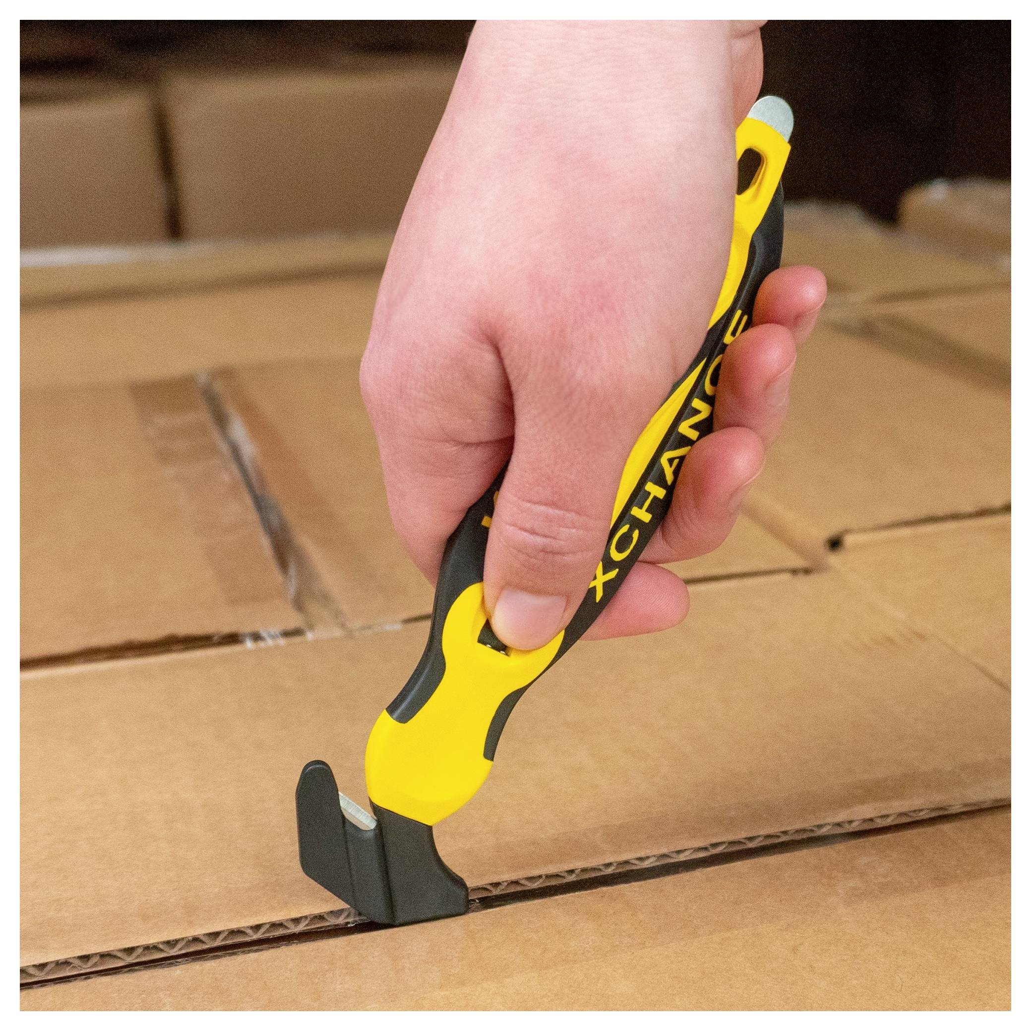 Hand holding a box cutter slicing open a cardboard shipping box.