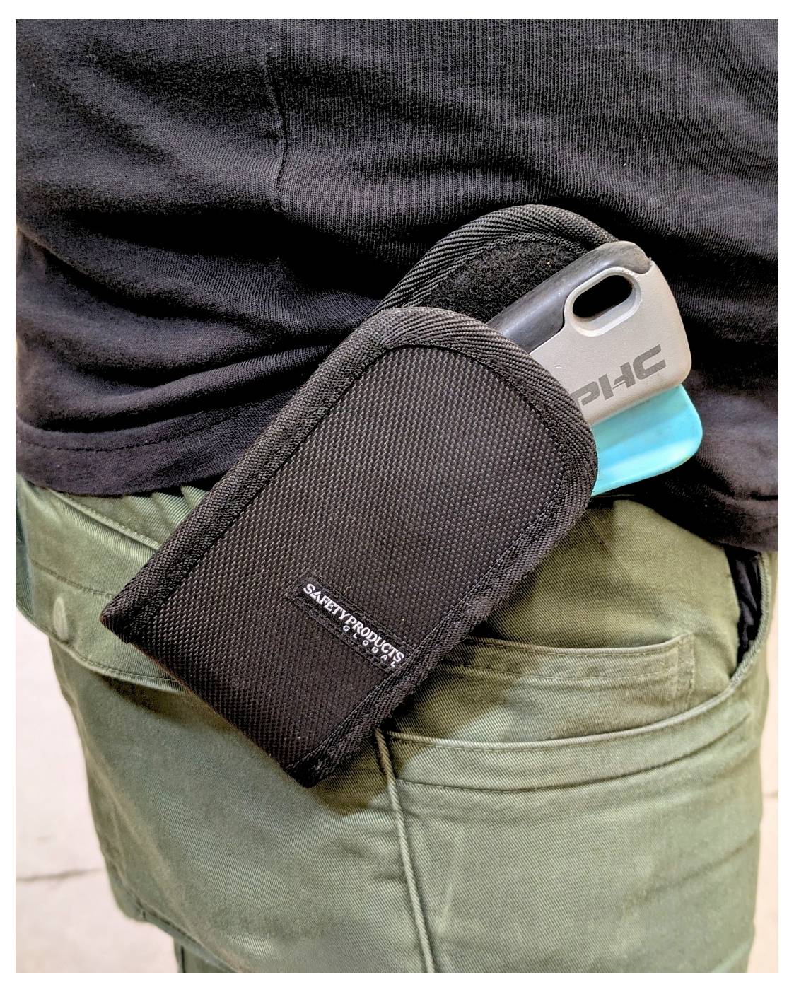 Small black fabric pouch clipped to a person's olive pants pocket, holding a smartphone with a blue case.<br>
