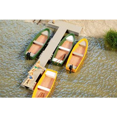 Miniature dock with four colorful boats moored in calm water, with two small figures on the pier near the shore.
