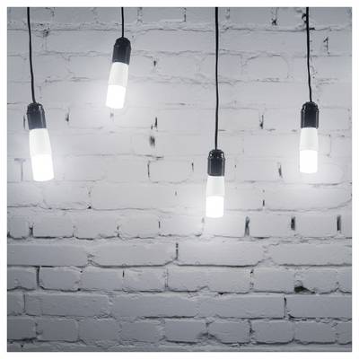 Four hanging lit light bulbs in front of a white painted brick wall.<br>