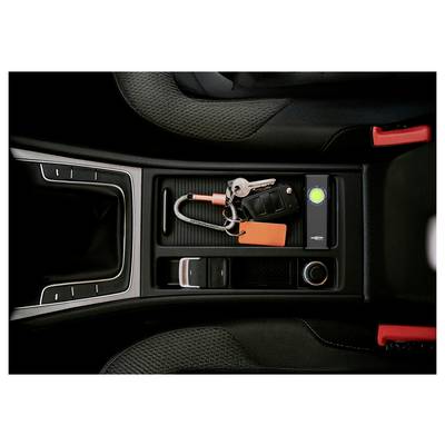 Car center console storage tray holding car keys, a key fob, and an orange tag beside a lit green indicator button.