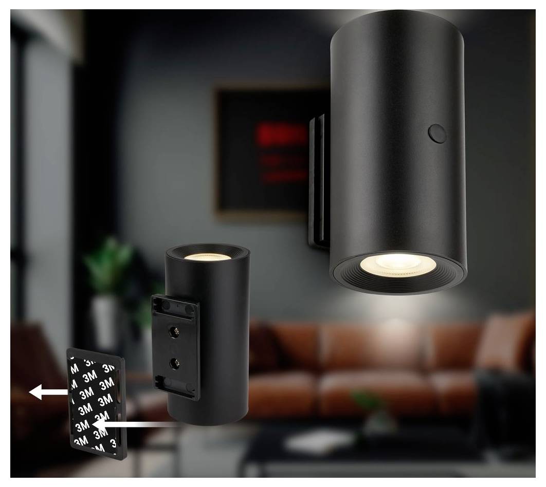 Black cylindrical wall/ceiling spotlight with mounting plate and adhesive backing, shown in a living room setting with arrows indicating installation steps.
