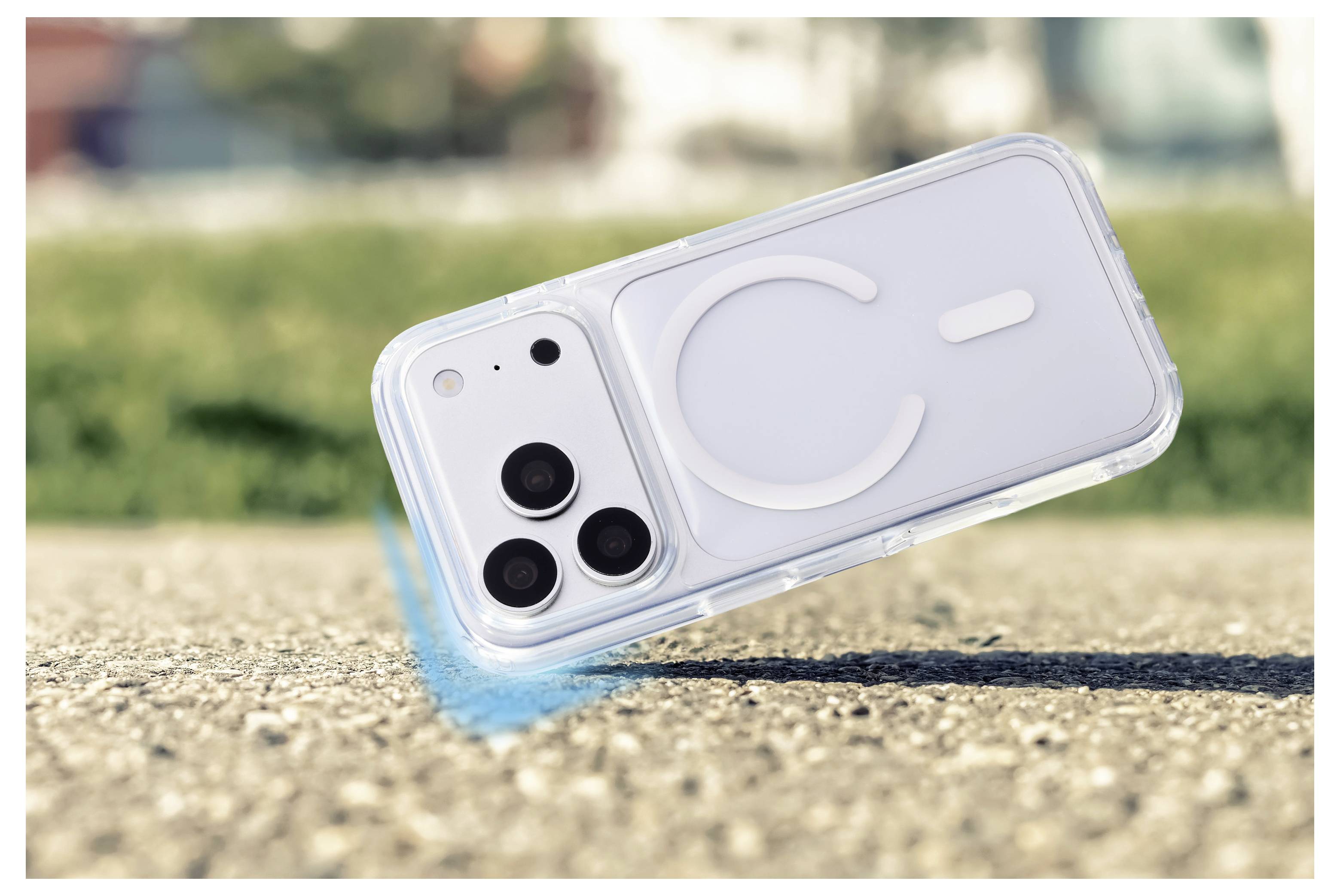 A clear smartphone case with a large 'C' leans on a concrete surface outdoors, with the phone’s rear cameras visible.