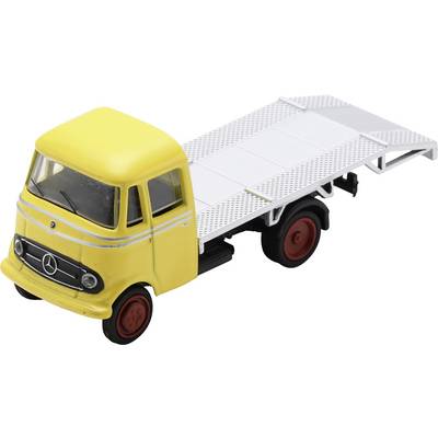 Yellow toy flatbed truck with white trailer and red wheels, shown in side view on a white background