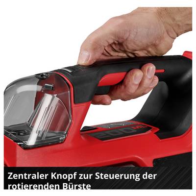 Close-up of a hand operating a red and black cordless vacuum cleaner handle with a central button; text: 'Central button for controlling the rotating brush'.