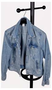 Light blue denim jacket hanging on a black clothes rack against a plain light background.