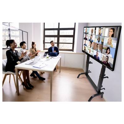 Four coworkers in a bright office applaud during a video conference shown on a large screen.<br>