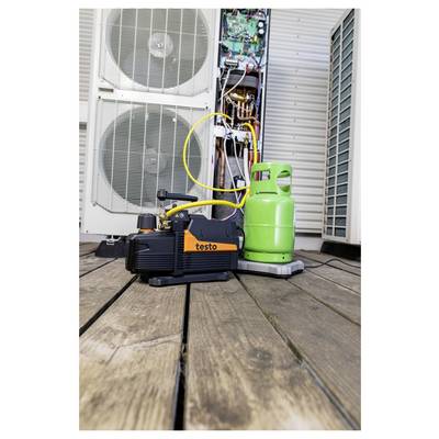 Vacuum pump and green refrigerant tank connected to outdoor HVAC unit for servicing or refrigerant recovery.