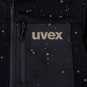 Close-up of a black uvex jacket with water droplets, showing a zippered front pocket and the 'uvex' logo.<br>