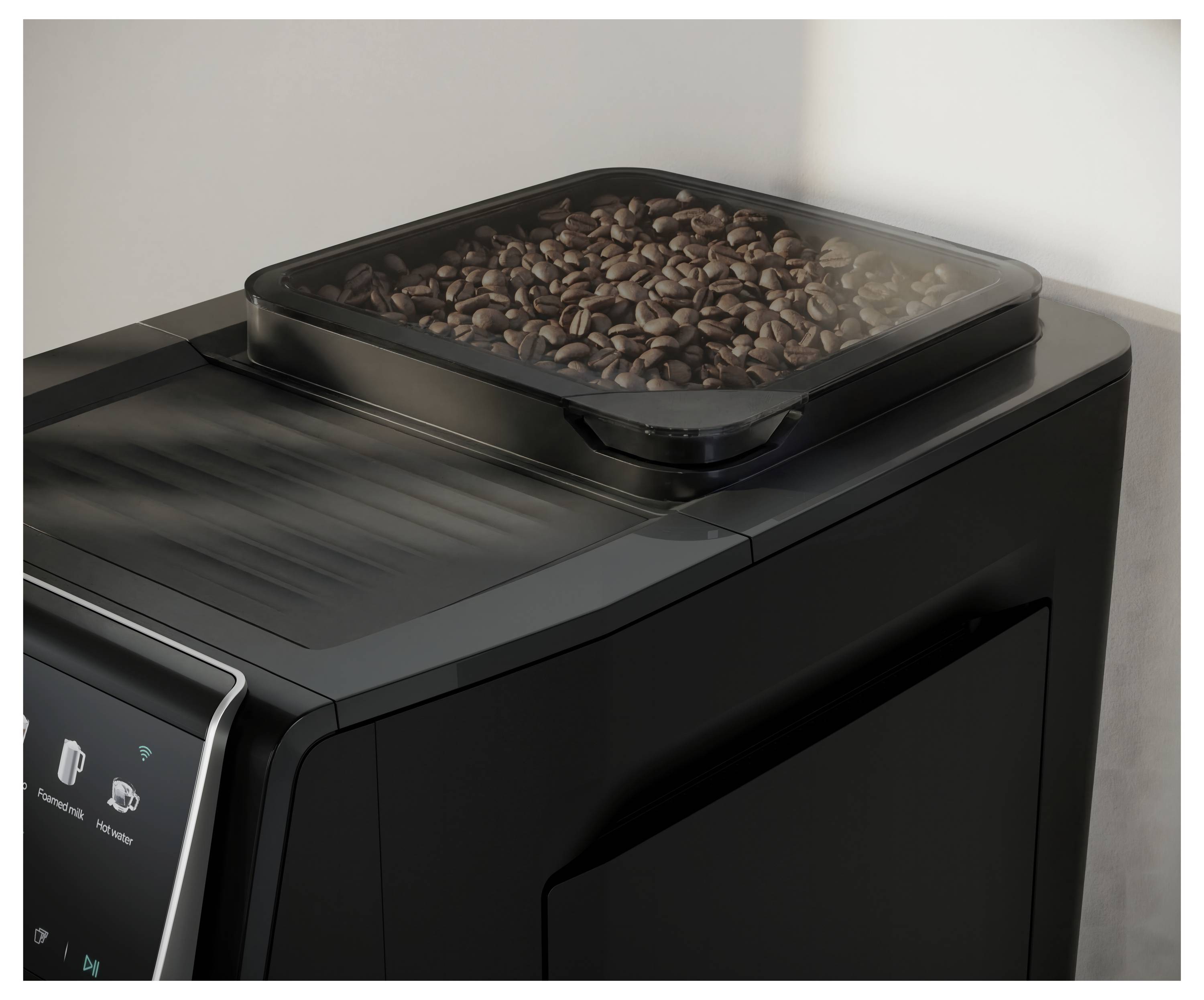 Coffee beans in a transparent hopper on top of a black automatic coffee machine.