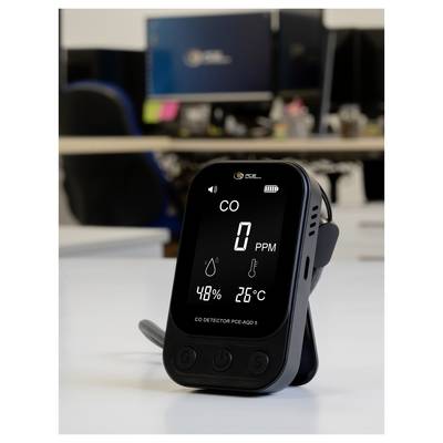 Portable CO detector on a desk, showing 0 PPM, 48% humidity, and 26°C on its screen.