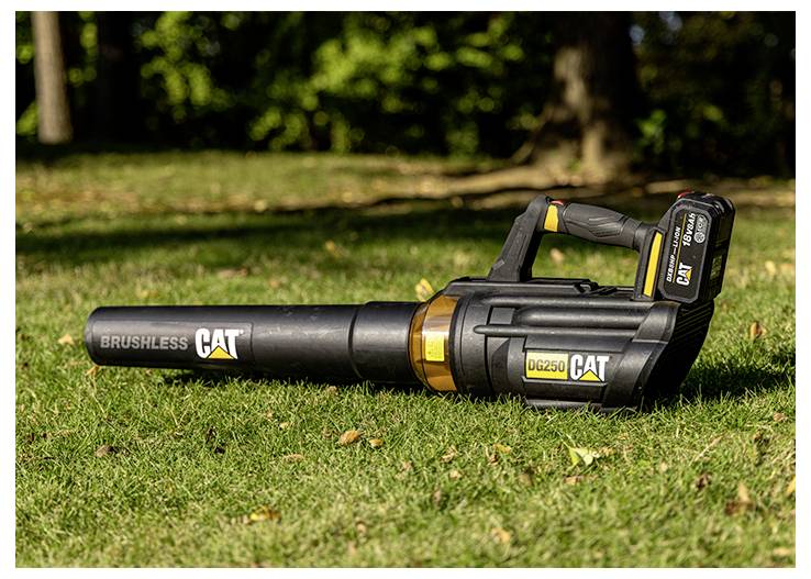 CAT cordless leaf blower lying on grass outdoors, shown with battery attached and 'BRUSHLESS' branding visible.