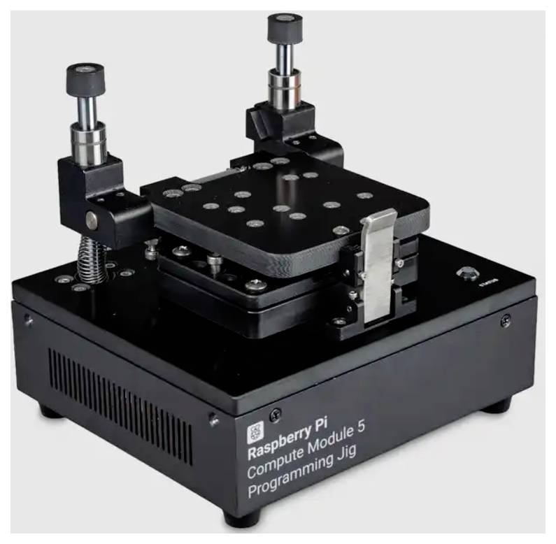 Raspberry Pi Compute Module 5 programming jig with adjustable clamps and a perforated mounting plate on a black base.<br>