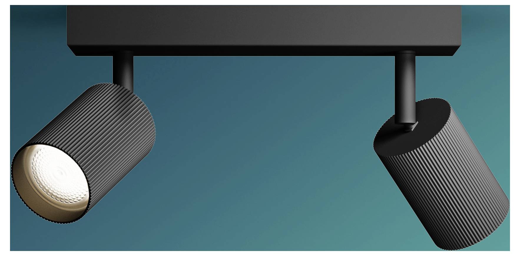 Two black track lights on a ceiling rail, both angled downward against a teal background.