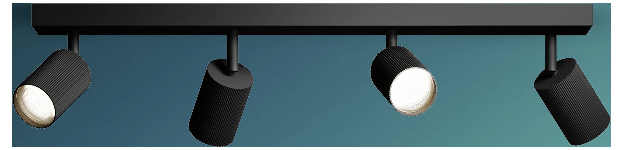 Four black track lights on a ceiling rail, with two spotlights turned on against a teal background.