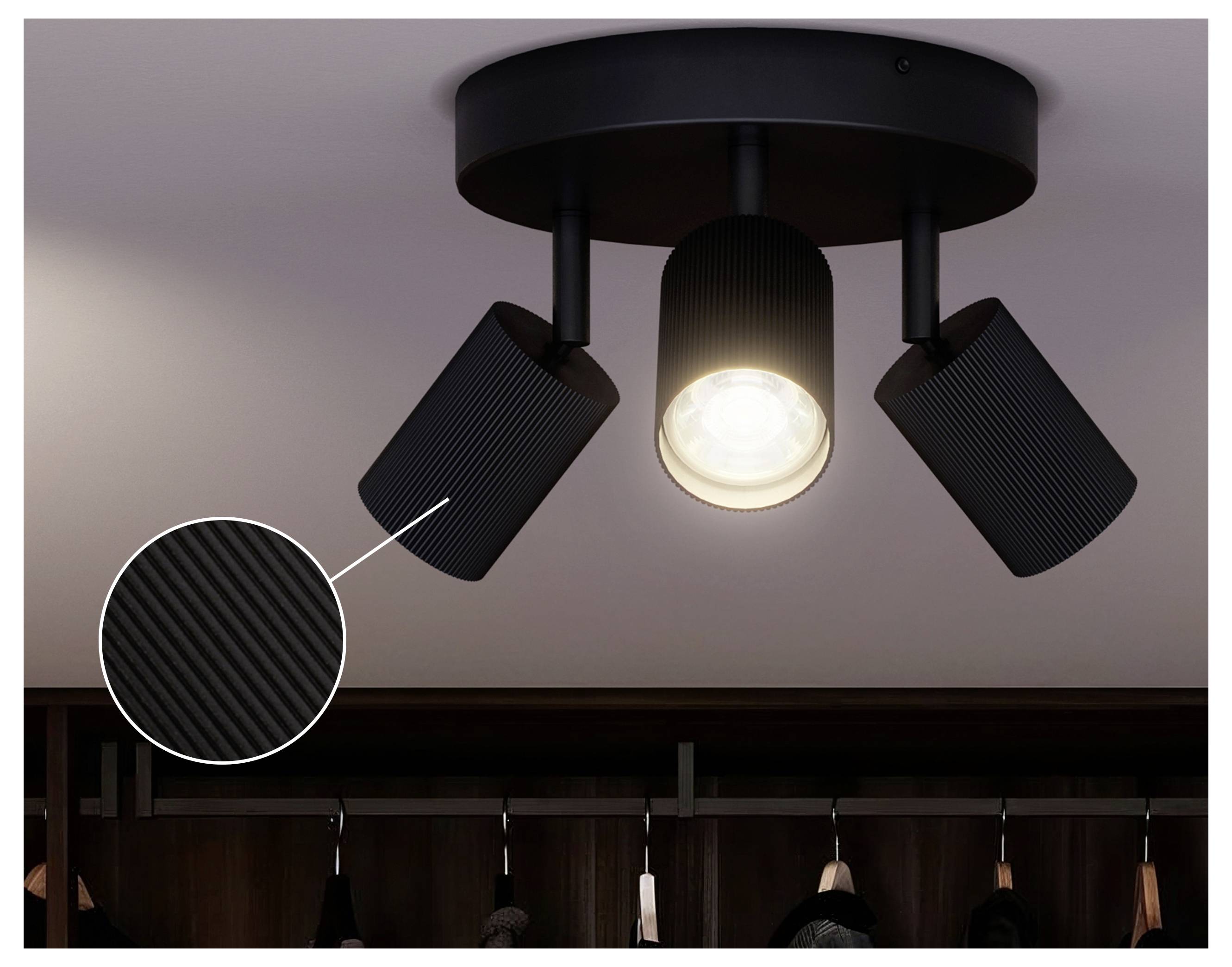 Black three-light ceiling spotlight fixture with one bulb lit, shown with a close-up inset of the textured finish.