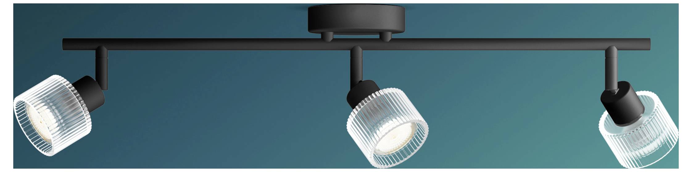Three adjustable track lights mounted on a ceiling rail against a teal background.