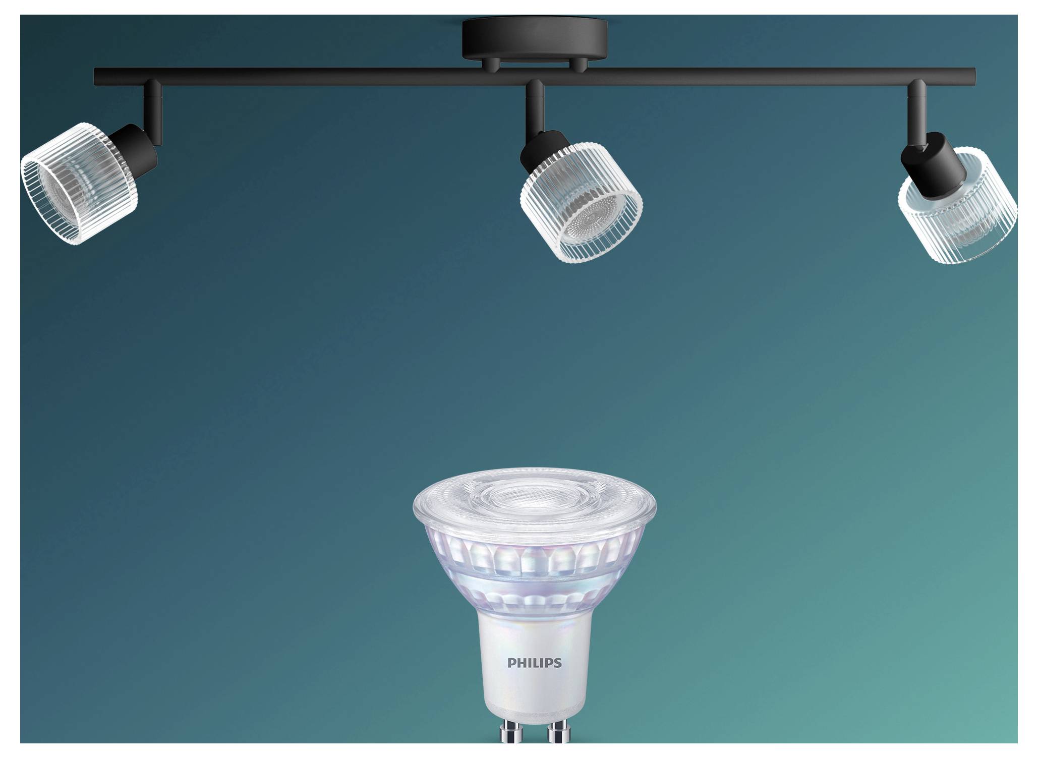 Three ceiling spotlights illuminate a Philips LED spotlight bulb against a teal background.