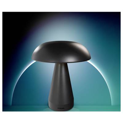 A modern black mushroom-shaped lamp centered against a blue-green glowing background with a white arc behind it.